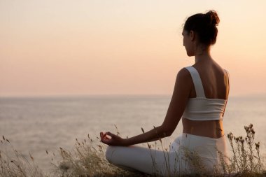 Denize yakın meditasyon yapan bir kadın. Metin için boşluk