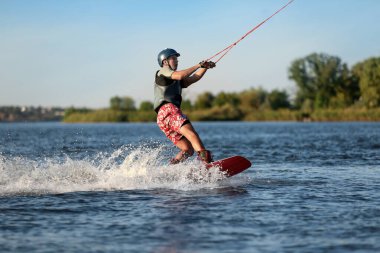 Genç çocuk nehirde wakeboard yapıyor. Aşırı su sporu