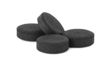 Beyaz arka planda aktif kömür hapları. Etkili sorbent