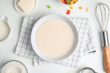 Düz kompozisyon, çiğ hamur, şekerli meyve ve beyaz masada kurabiye için diğer malzemeler.