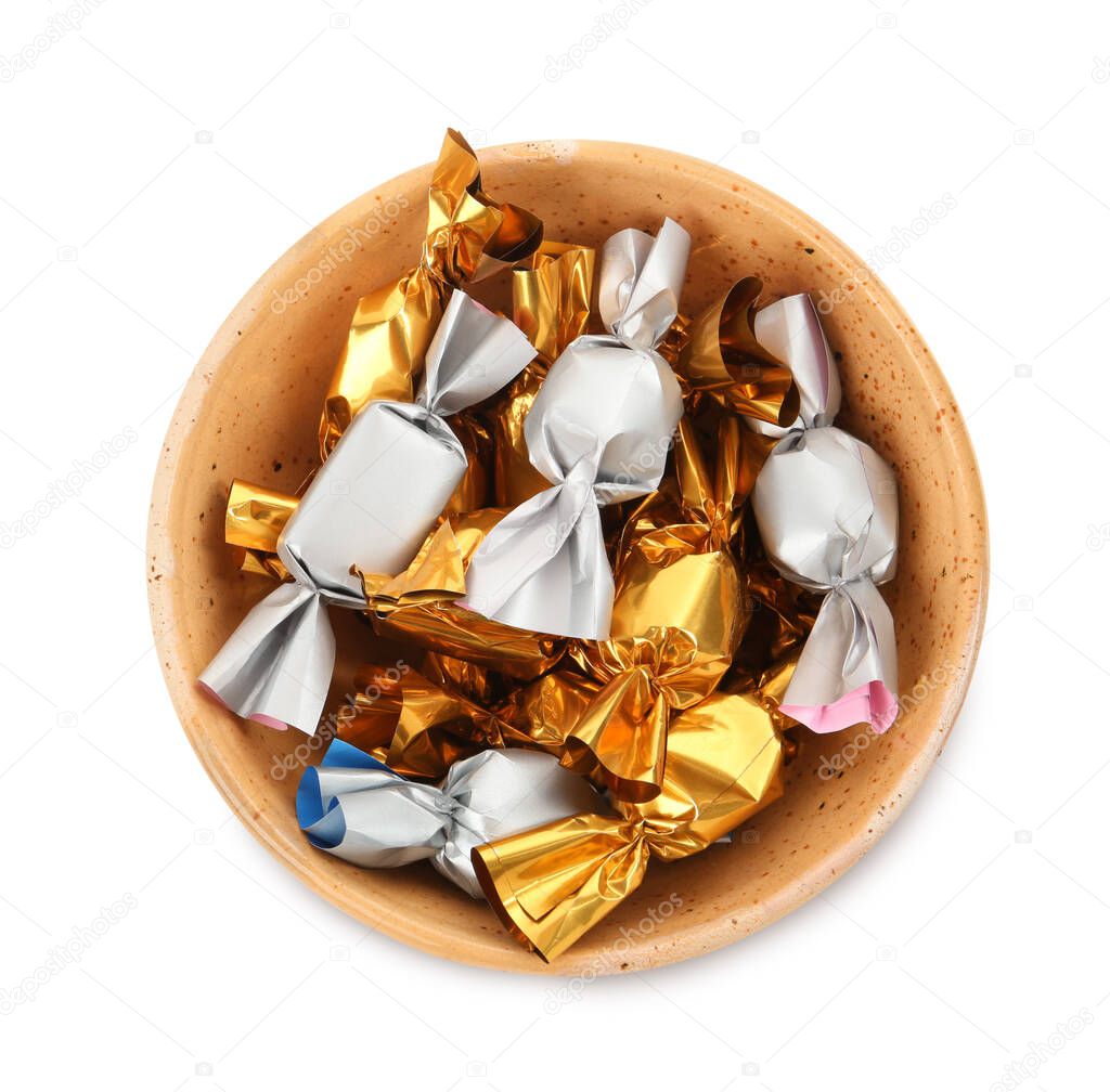 Bowl with candies in golden and silver wrappers isolated on white, top view