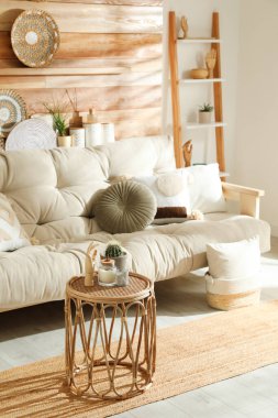 Şık bir dekor ve oturma odasındaki ahşap duvarın yanındaki rahat kanepe. İç tasarım