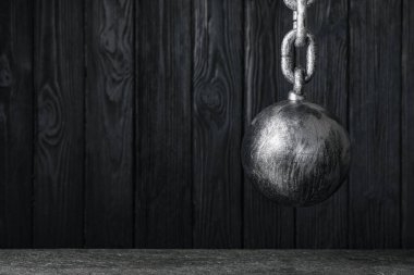 Siyah ahşap duvarda asılı zincirli mahkum topu, metin için boşluk