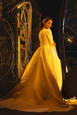 Genç gelin dışarıda güzel bir gelinlik giyiyor.