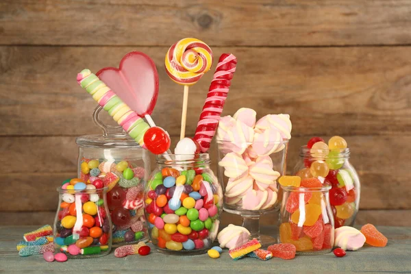 Üvegek Különböző Ízletes Cukorkák Világoskék Asztalon — Stock Fotó