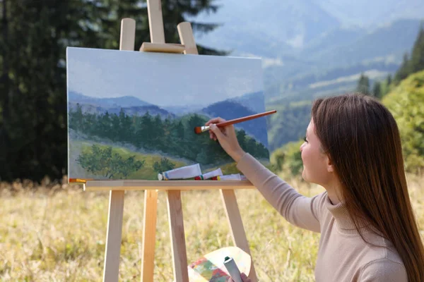 山の中でイーゼルを描く若い女性 — ストック写真