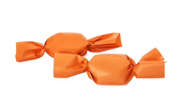 Heerlijke Snoepjes Oranje Wrappers Witte Achtergrond — Stockfoto