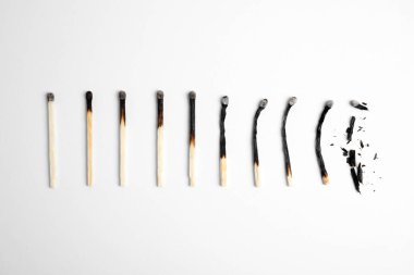 Beyaz arkaplanda yanmış kibritlerin farklı aşamaları, düz yatış