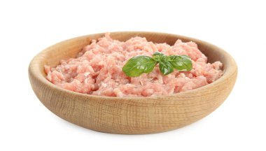 Beyaz arka planda fesleğenle doğranmış çiğ tavuk eti.