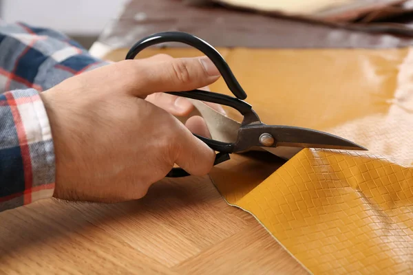 Man Cutting Orange Leather Scissors Wooden Table Closeup — Stock Photo, Image