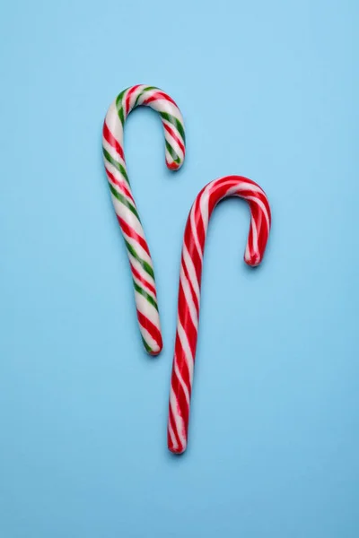Açık Mavi Arka Planda Iki Tatlı Noel Şeker Kamışı Düz — Stok fotoğraf
