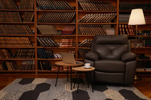 舒适舒适的家庭图书馆内部 有皮革扶手椅 笔记本电脑和书架上收藏的古籍 — 图库照片