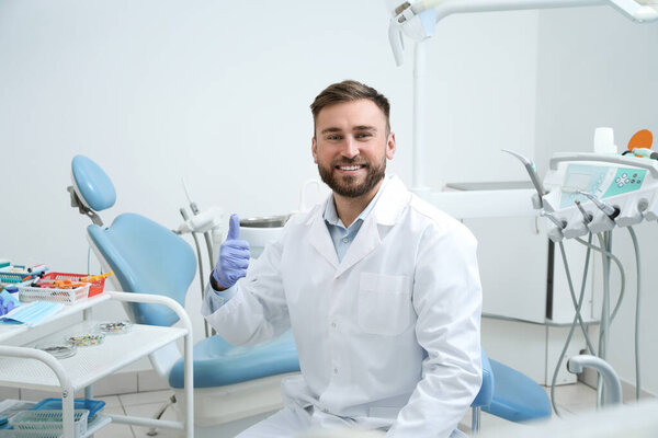 Portrait of professional dentist at workplace in clinic