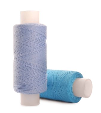 Beyaz arkaplanda farklı renkli dikiş iplikleri