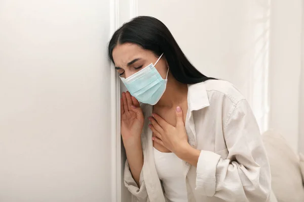 自宅で呼吸の問題に苦しんで保護マスクを持つ若い女性 — ストック写真