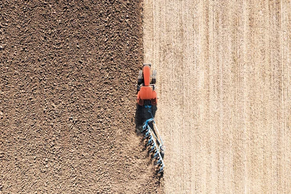 晴れた日に農地で耕起を引くトラクター 空の景色 — ストック写真