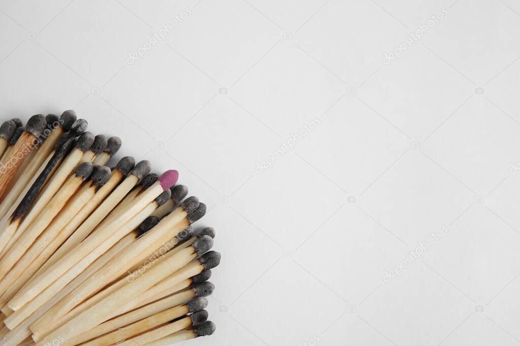 Heap of burnt matches and whole one on white background, flat lay. Space for text