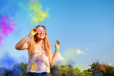 Açık havada renkli pudra boyalarıyla kaplanmış mutlu kadın, mesaj için yer. Holi festivali kutlaması