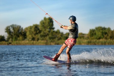 Genç çocuk nehirde wakeboard yapıyor. Aşırı su sporu