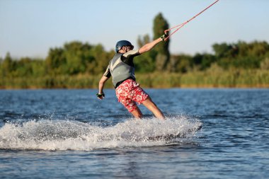 Genç çocuk nehirde wakeboard yapıyor. Aşırı su sporu