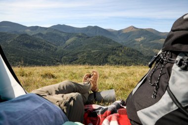 Dağlardaki kamp çadırında dinlenen bir turist, yakın plan.