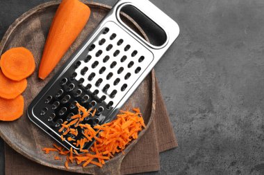 Öğütücü ve taze olgun havuç gri masada, üst manzara. Metin için boşluk