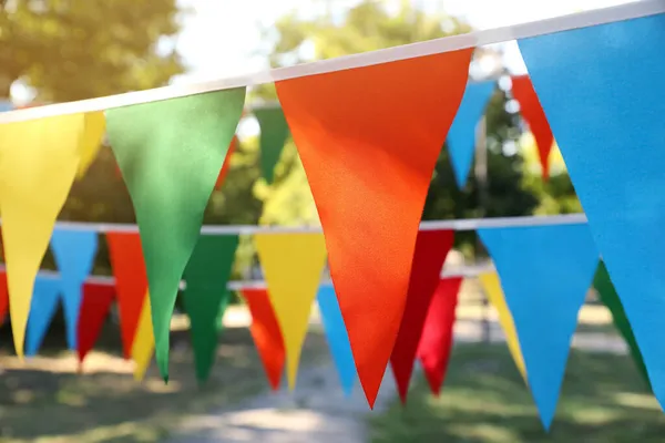 Colorful bunting flags in park. Party decor