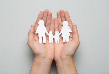 Açık gri arka planda kağıt aile kesimi olan kadın, üst görünüm