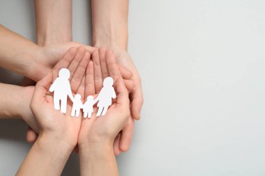 Açık gri arka planda kağıt aile kesimi olan insanlar, üst manzara. Metin için boşluk