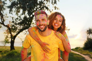 Açık havada renkli pudra boyalarıyla kaplı mutlu çift. Holi festivali kutlaması