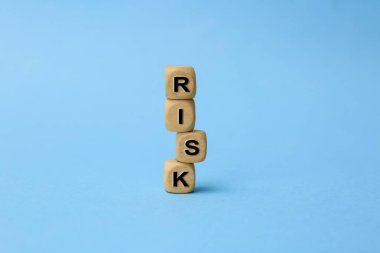 Sözcüklerle dolu ahşap küpler Açık mavi arka planda risk