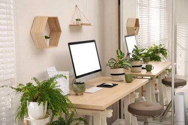 Modern bilgisayar ve ev bitkileriyle dolu rahat bir iş yeri. İç tasarım