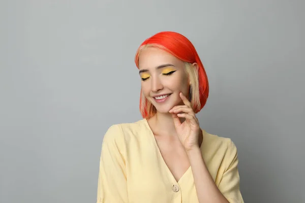 明るい染めの髪を持つ美しい若い女性ライトグレーの背景 — ストック写真