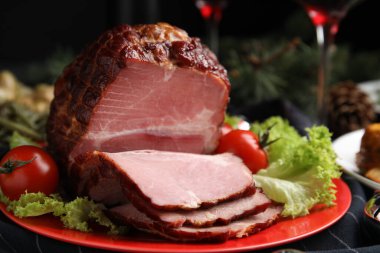 Lezzetli jambonlu tabak, marul ve domatesler siyah ahşap masada, yakın plan.