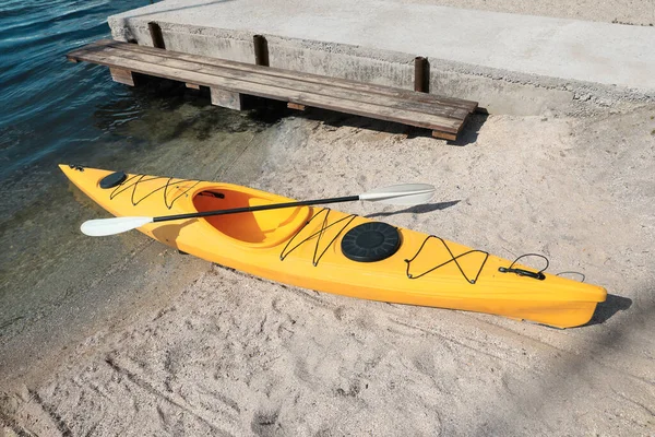 川の近くのビーチでパドル付きの黄色のカヤック サマーキャンプ活動 — ストック写真