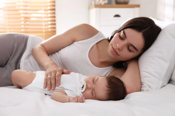 Young Mother Resting Her Sleeping Baby Bed Home — ストック写真