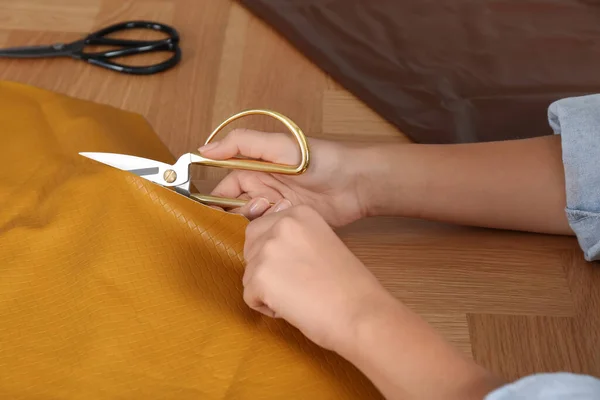 Woman Cutting Orange Leather Scissors Wooden Table Closeup — Stock Photo, Image