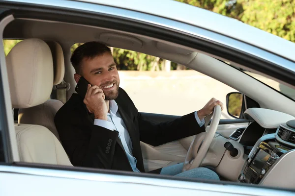 Przystojny Młody Kierowca Rozmawiający Przez Telefon Nowoczesnym Samochodzie — Zdjęcie stockowe