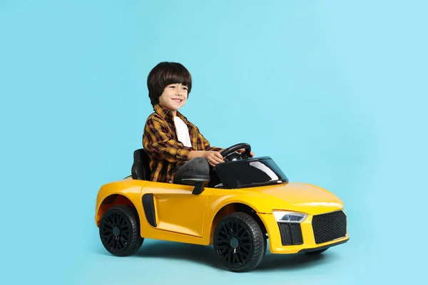 Klein Kind Rijden Gele Speelgoed Auto Lichtblauwe Achtergrond — Stockfoto