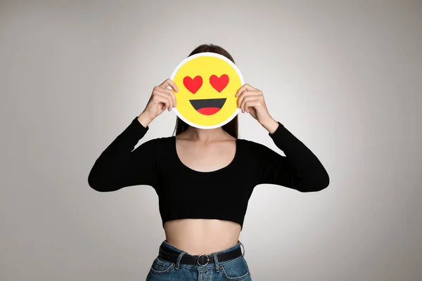 Woman Covering Face Heart Eyes Emoji Grey Background — Stock Photo, Image