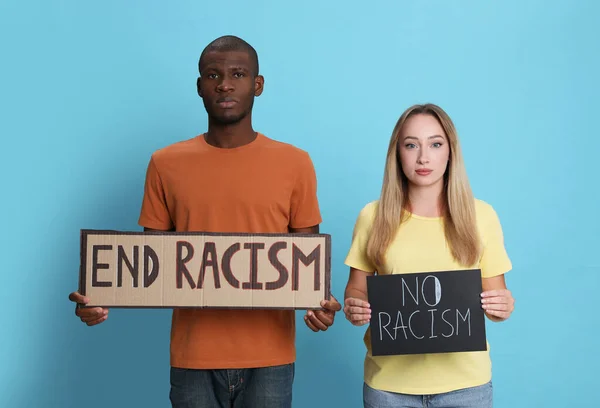 若い女性とアフリカ系アメリカ人の男性は ライトブルーの背景にフレーズエンド人種主義と兆候を保持 — ストック写真