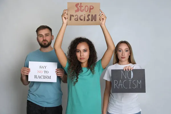 灰色の背景に標識を保持する人々のグループ 人種主義の概念 — ストック写真