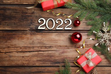 Mutlu yıllar tebrik kartı. 2022 sayılı düz kompozisyon ve ahşap arka planda şenlikli dekor