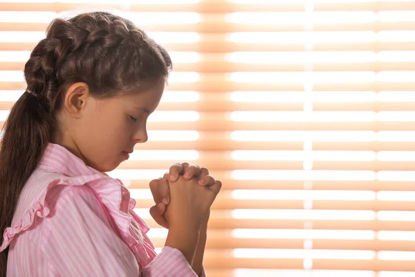 Χαριτωμένο Κοριτσάκι Χέρια Ενωμένα Προσεύχεται Κοντά Στο Παράθυρο Χώρος Για — Φωτογραφία Αρχείου