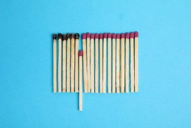 Flat lay composition with burnt and whole matches on light blue background clipart
