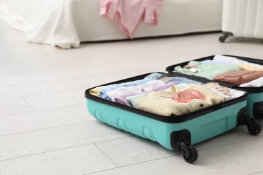 Odada giysilerle dolu bir bavul var. Metin için boşluk