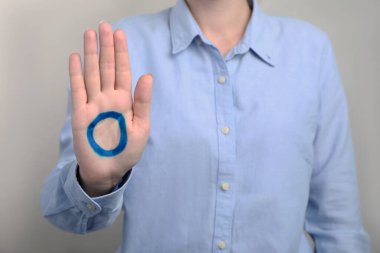 Avuç içine çizilmiş mavi halkalı bir kadın açık gri arka planda, yakın plan. Dünya Diyabet Günü