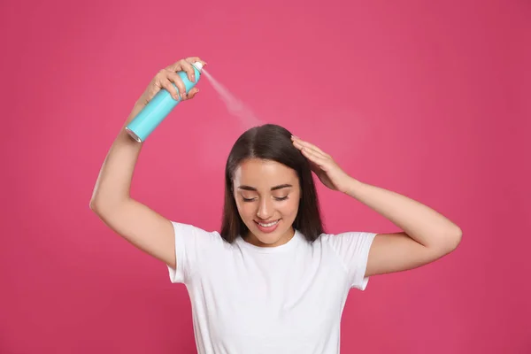 Genç Bir Kadın Pembe Arka Plana Kuru Şampuan Sürüyor — Stok fotoğraf