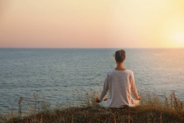 Deniz kenarında meditasyon yapan bir kadın. Metin için boşluk