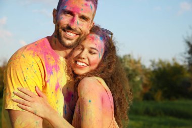 Açık havada renkli pudra boyalarıyla kaplı mutlu çift. Holi festivali kutlaması